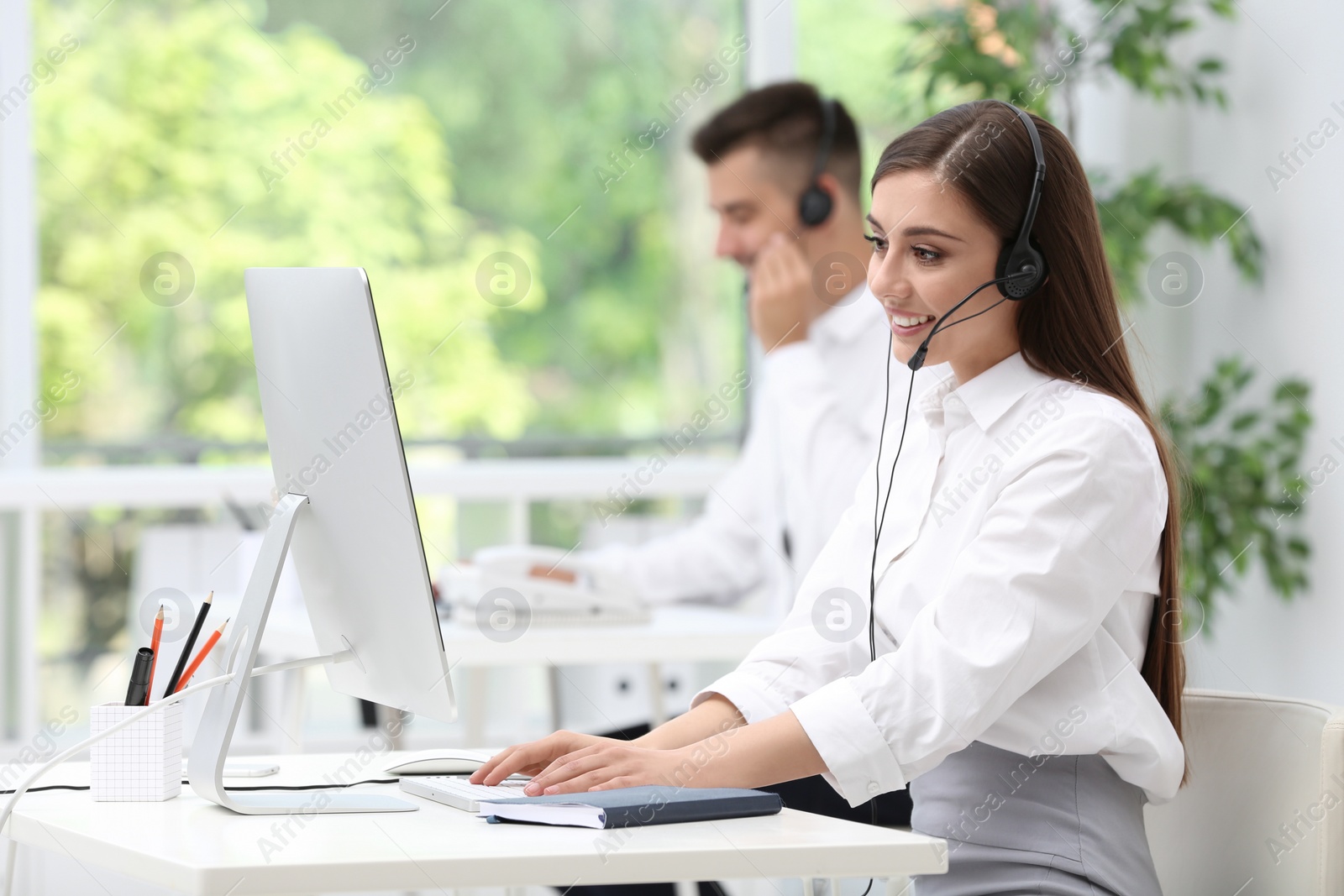 Photo of Female receptionist with headset at desk in office