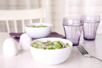 Photo of Delicious fresh cucumber onion salad served on table