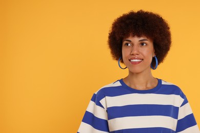 Photo of Portrait of happy young woman on orange background. Space for text