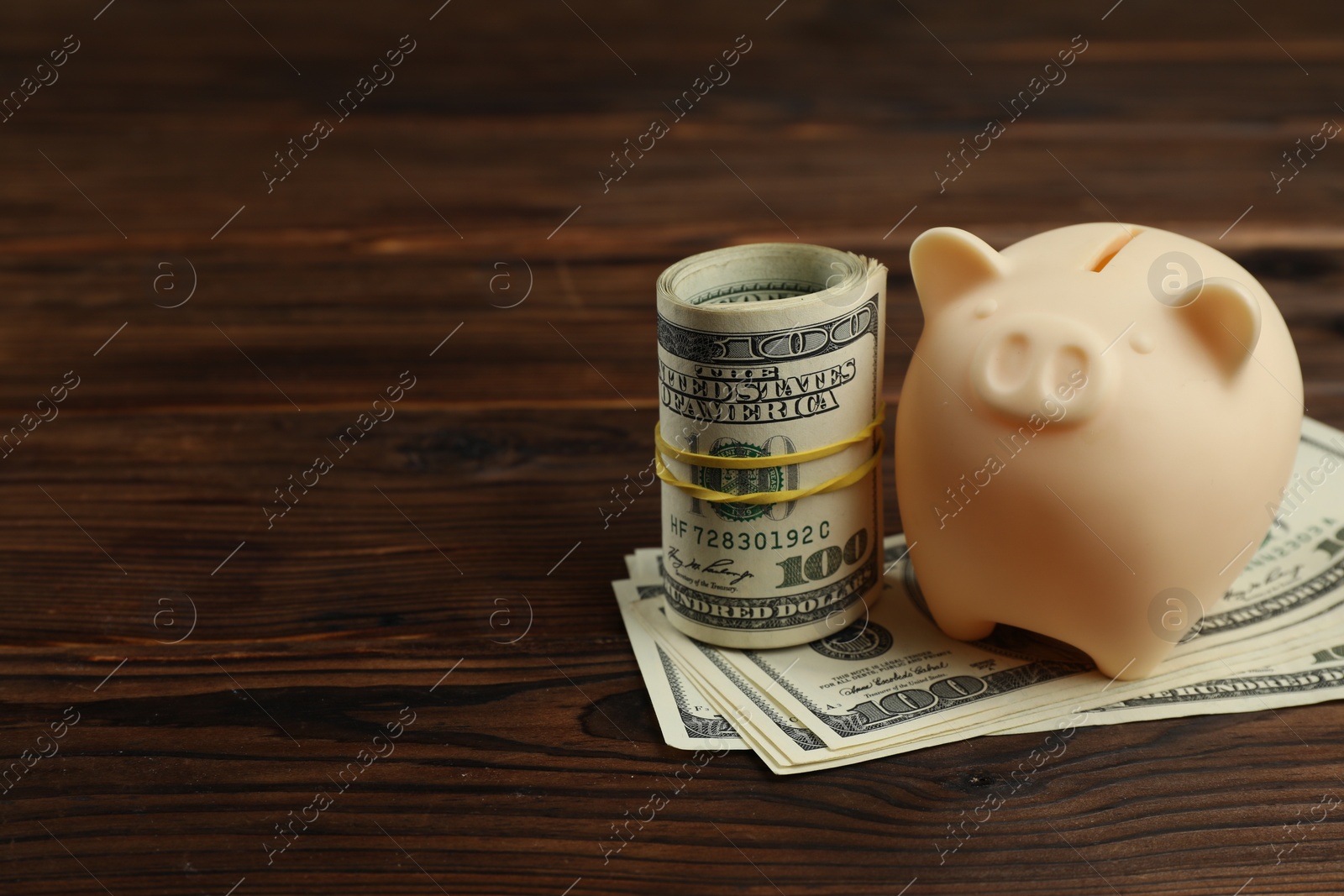 Photo of Money exchange. Dollar banknotes and piggy bank on wooden background. Space for text
