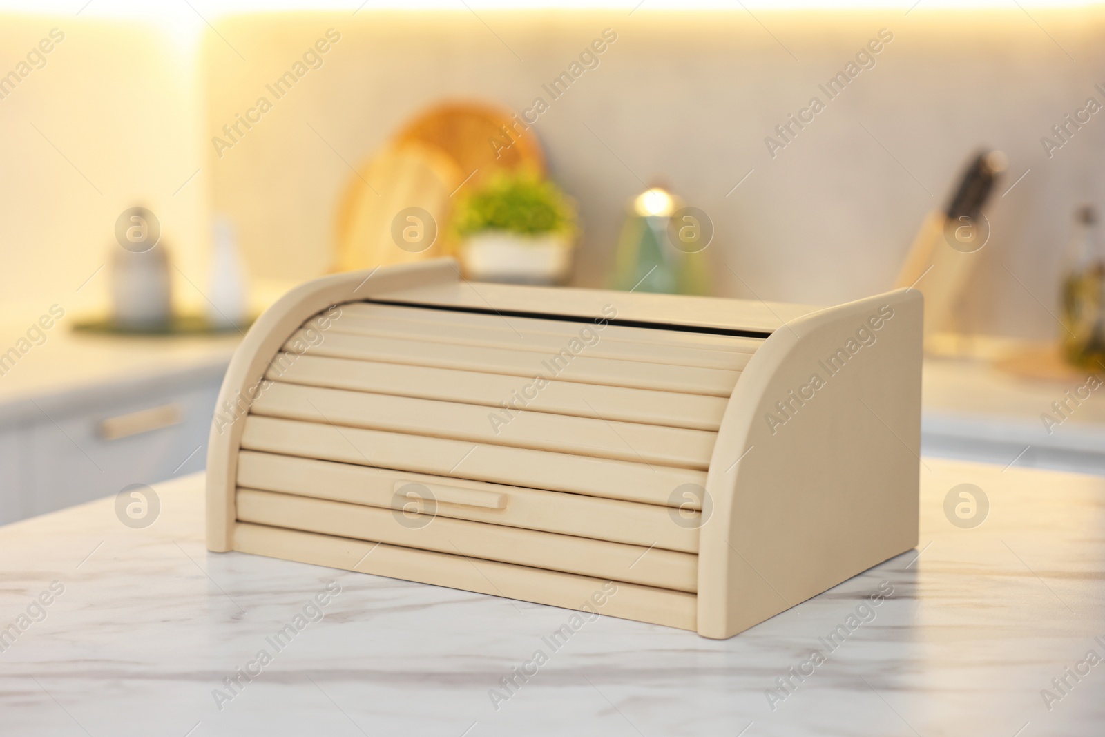 Photo of Wooden bread box on white marble table in kitchen, closeup