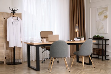 Modern medical office interior with doctor's workplace and chairs