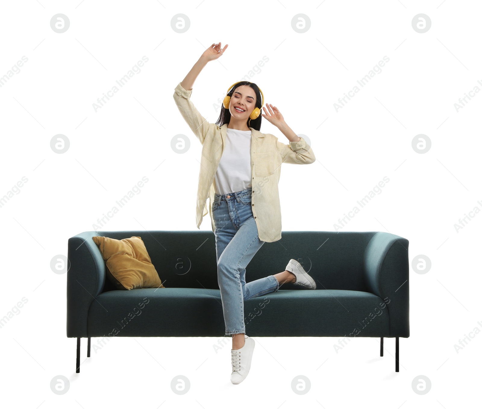 Photo of Young woman listening to music on comfortable green sofa against white background