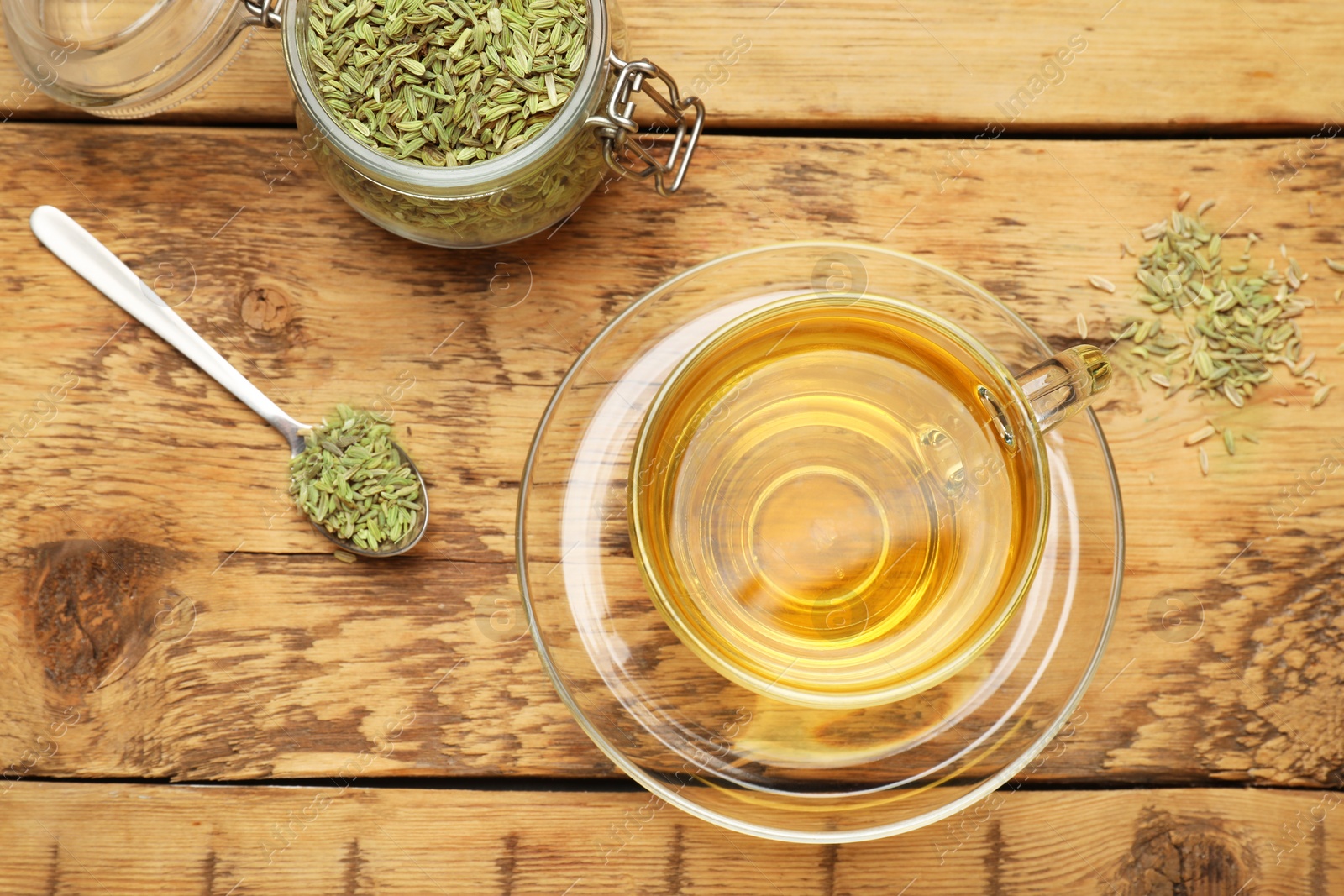 Photo of Aromatic fennel tea and seeds on wooden table, flat lay