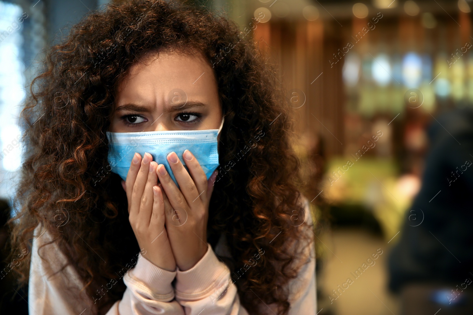 Photo of African-American woman with disposable mask in cafe. Virus protection