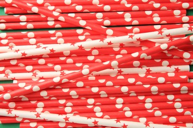 Photo of Many paper drinking straws on green background, above view