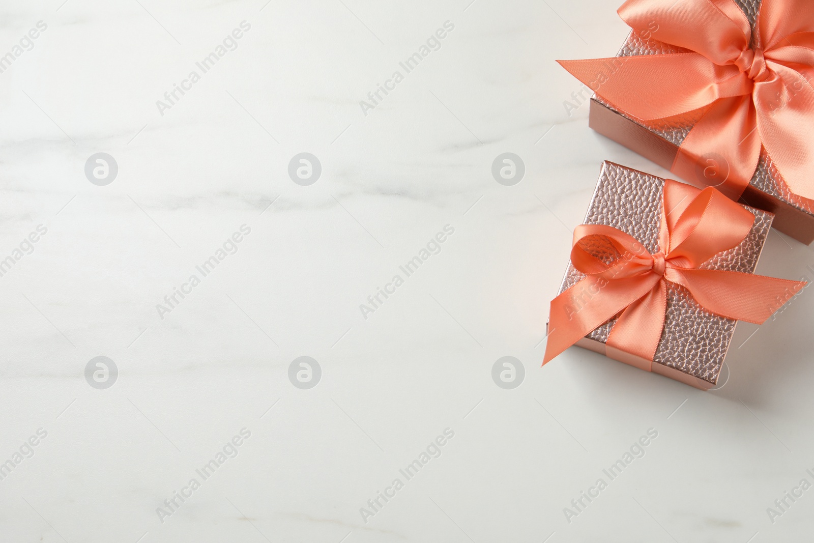 Photo of Beautiful gift boxes on white marble table, flat lay. Space for text