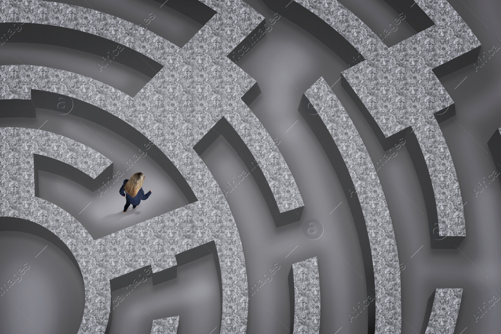 Image of Businesswoman trying to find way out of maze, above view