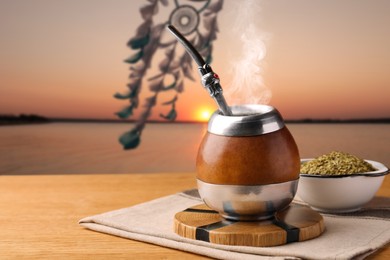 Image of Calabash with mate tea and bombilla on wooden table outdoors at sunset. Space for text