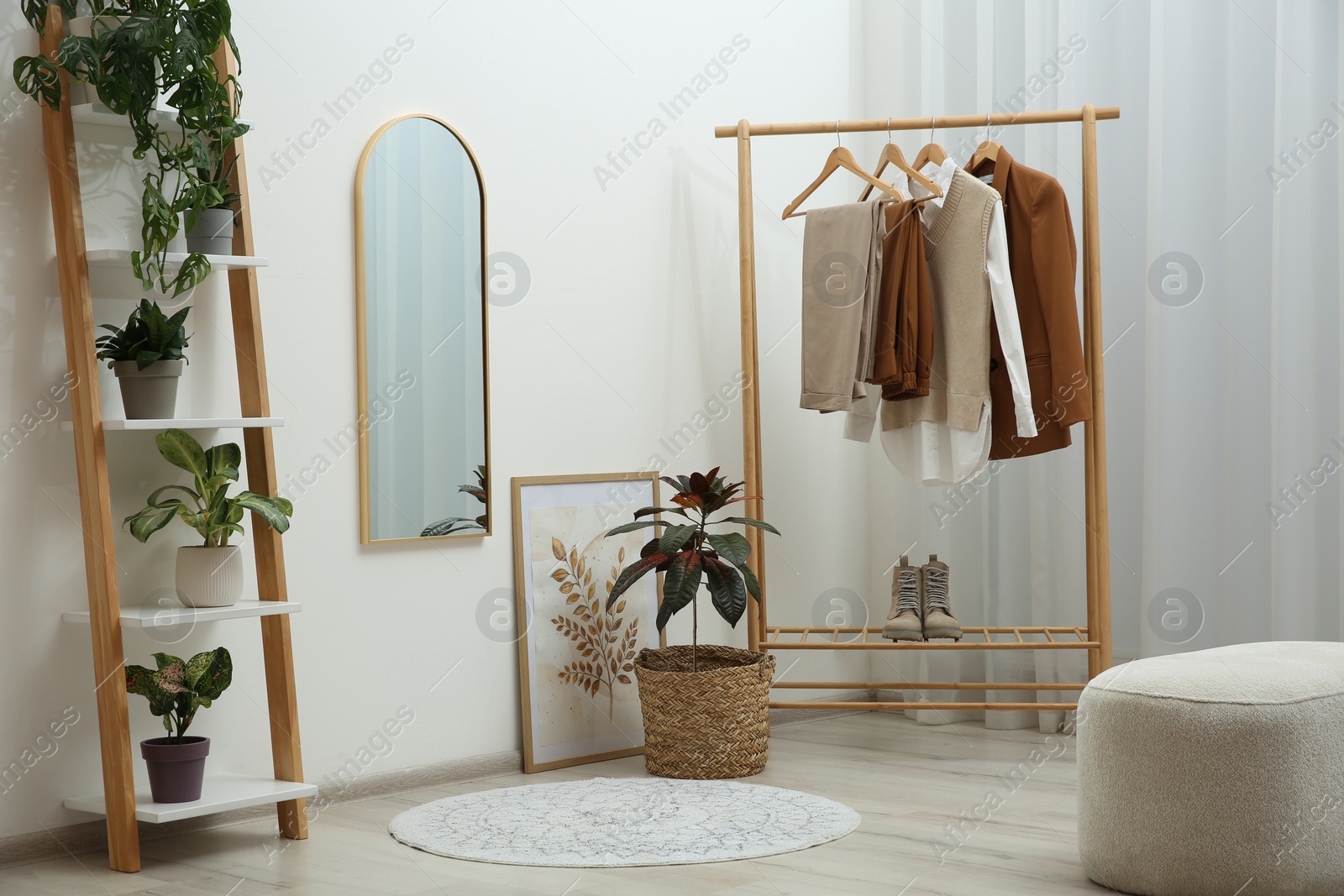 Photo of Dressing room interior with wooden furniture, mirror and houseplants. Stylish accessories