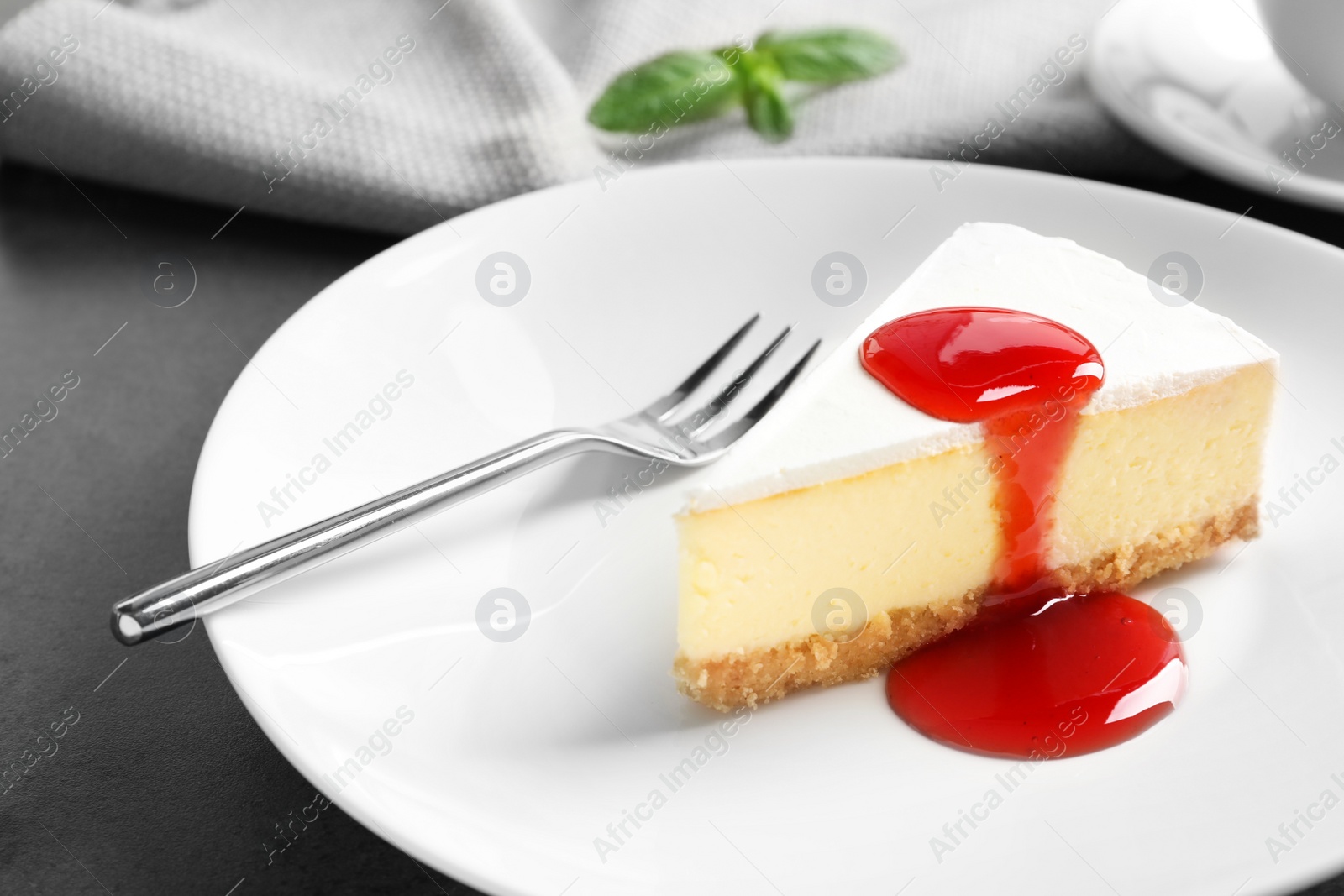 Photo of Delicious cheesecake served with sweet jam on plate