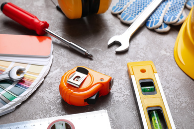 Many different construction tools on grey marble table