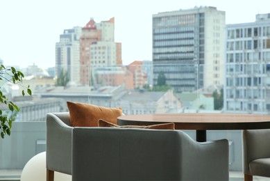 Photo of Observation area cafe. Table and armchairs on terrace against beautiful cityscape