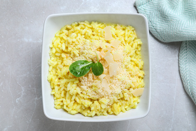 Photo of Delicious risotto with cheese on grey marble table, top view