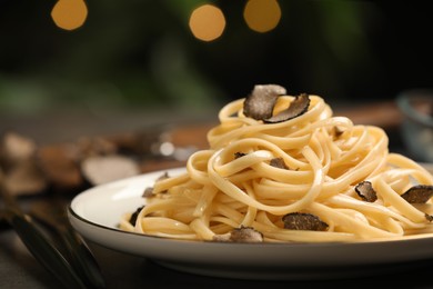 Photo of Tasty fettuccine with truffle on table, closeup