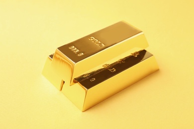 Photo of Precious shiny gold bars on color background