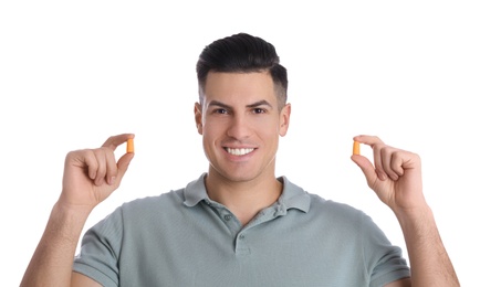 Man with foam ear plugs on white background