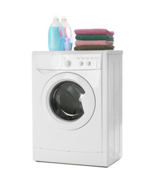Photo of Modern washing machine, stack of towels and detergents on white background. Laundry day
