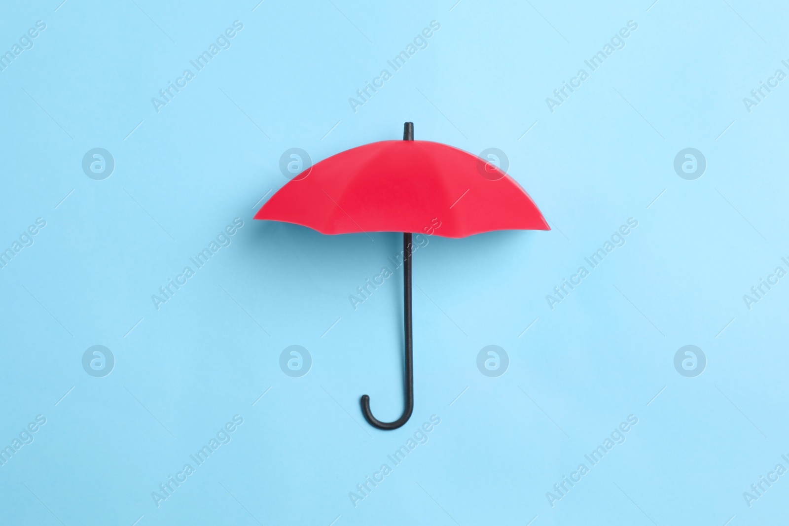 Photo of Bright toy umbrella on light blue background, top view