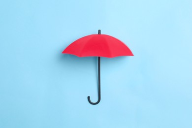 Photo of Bright toy umbrella on light blue background, top view