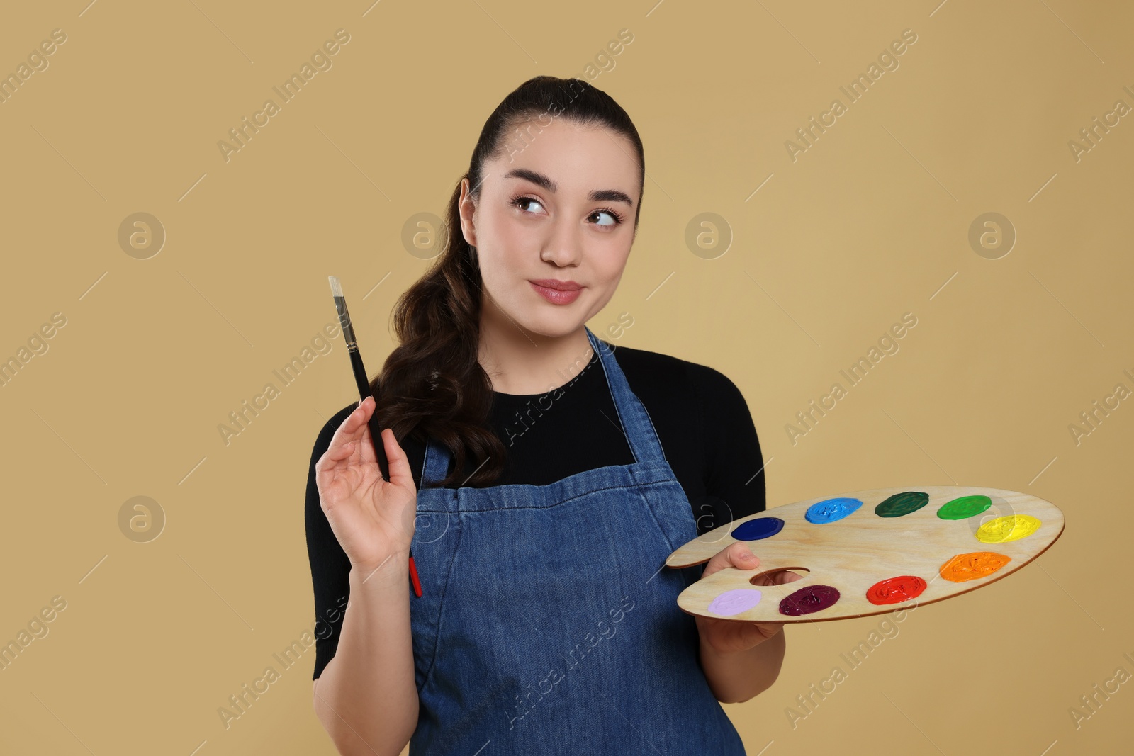 Photo of Woman with painting tools on beige background. Young artist