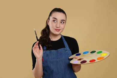 Woman with painting tools on beige background. Young artist