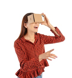 Young woman using cardboard virtual reality headset, isolated on white