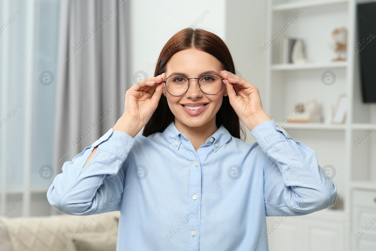 Photo of Portrait of smiling woman in stylish eyeglasses at home