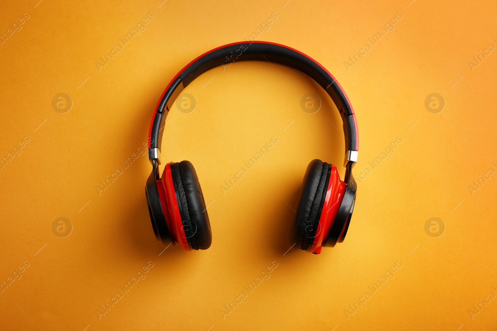 Photo of Wireless headphones on color background, top view