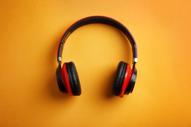 Photo of Wireless headphones on color background, top view