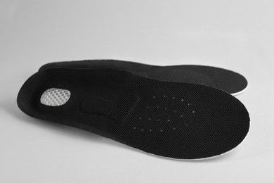 Pair of shoe insoles on light gray background