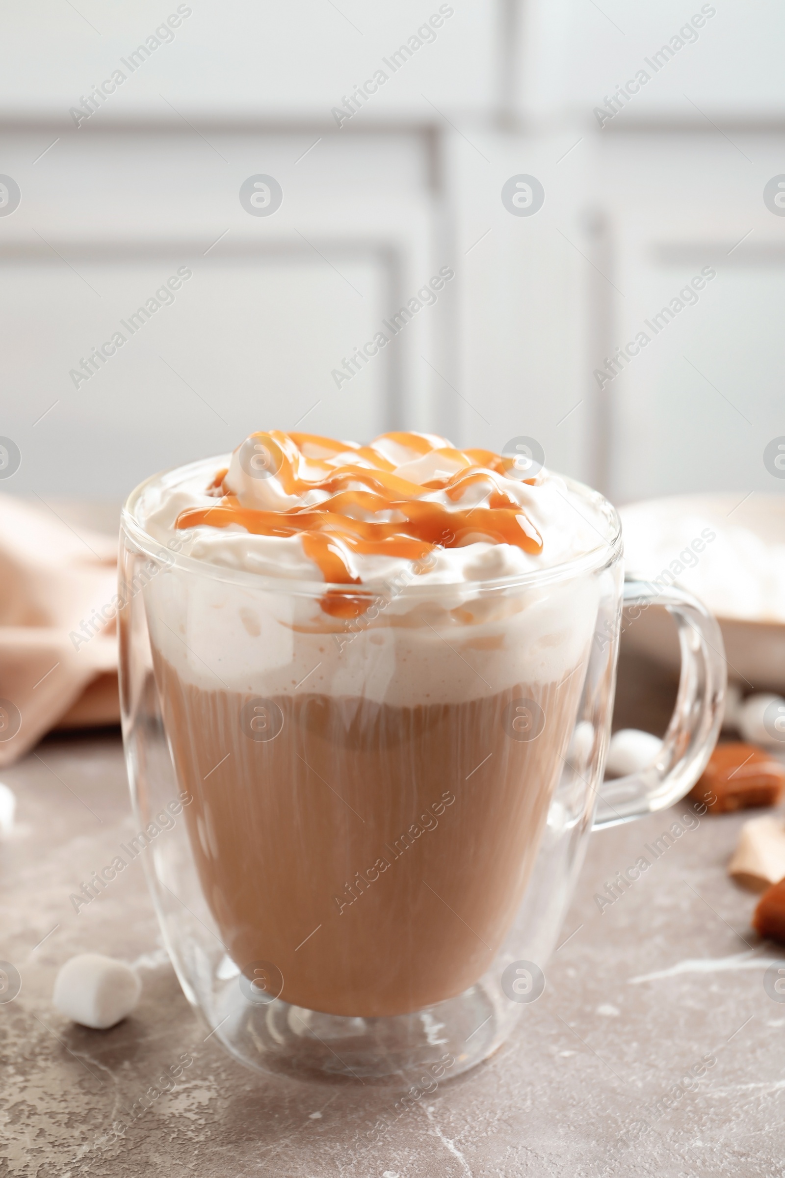 Photo of Cup of coffee with caramel topping on grey table