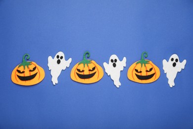 Photo of Pumpkins and ghosts on blue background. Halloween celebration