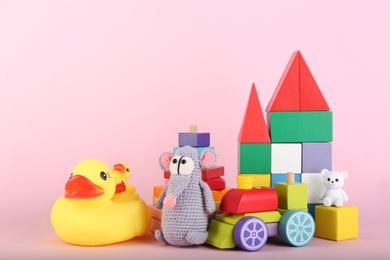 Photo of Set of different toys on pink background. Space for text