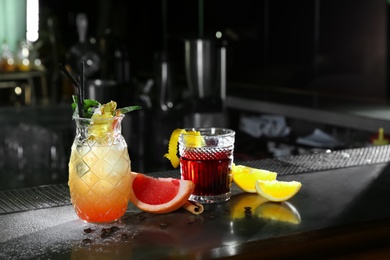 Fresh alcoholic cocktails in glasses on bar counter