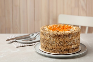 Photo of Sweet carrot cake with delicious cream on white marble table indoors, space for text