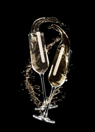 Image of Glasses with sparkling wine and splashes on black background