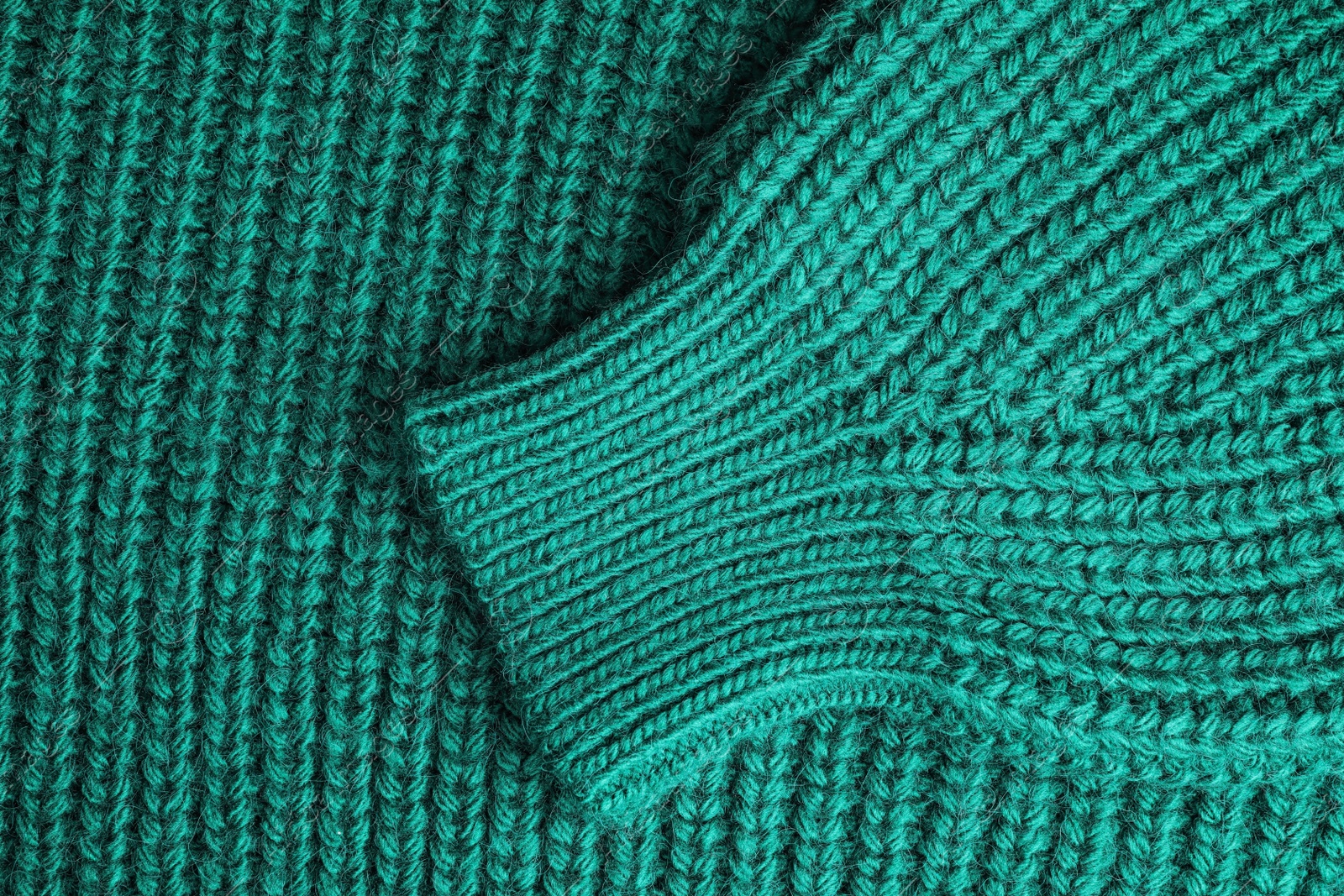 Photo of Green knitted sweater as background, closeup view