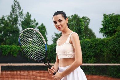 Photo of Professional sportswoman with tennis racket at court