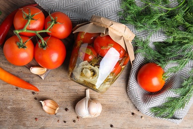 Photo of Flat lay composition with pickled tomatoes in glass jar on wooden table