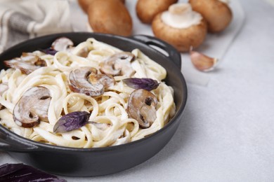 Photo of Delicious pasta with mushrooms on grey table, closeup