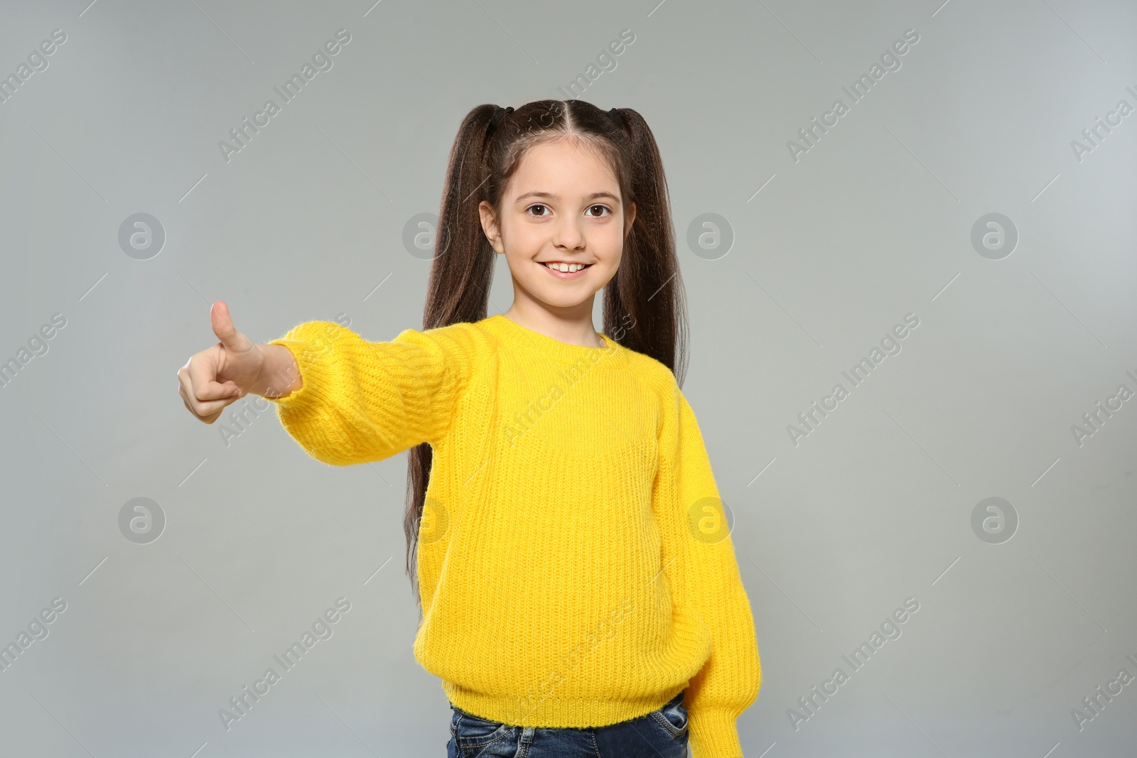 Photo of Portrait of little girl posing on grey background