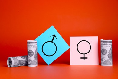 Gender pay gap. Male and female symbols near dollar banknotes on red background