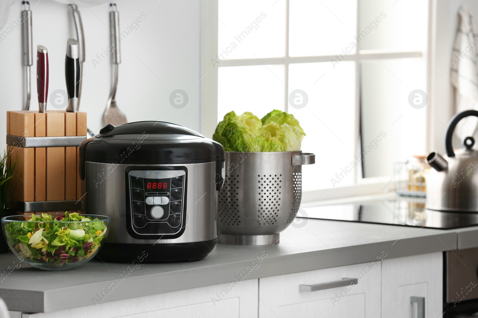 Photo of Modern electric multi cooker and food on kitchen countertop. Space for text