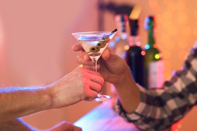 Photo of Young man taking martini cocktail from barman in pub, closeup