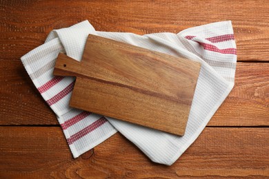 Photo of Kitchen towel and cutting board on wooden table, top view