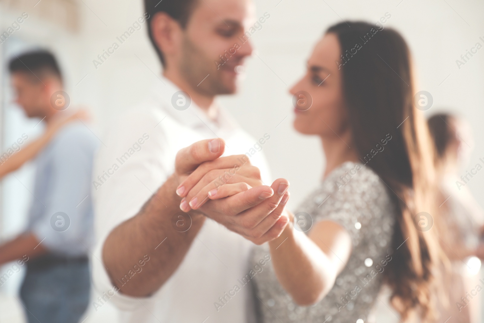 Photo of Young couple dancing at party, focus on hands