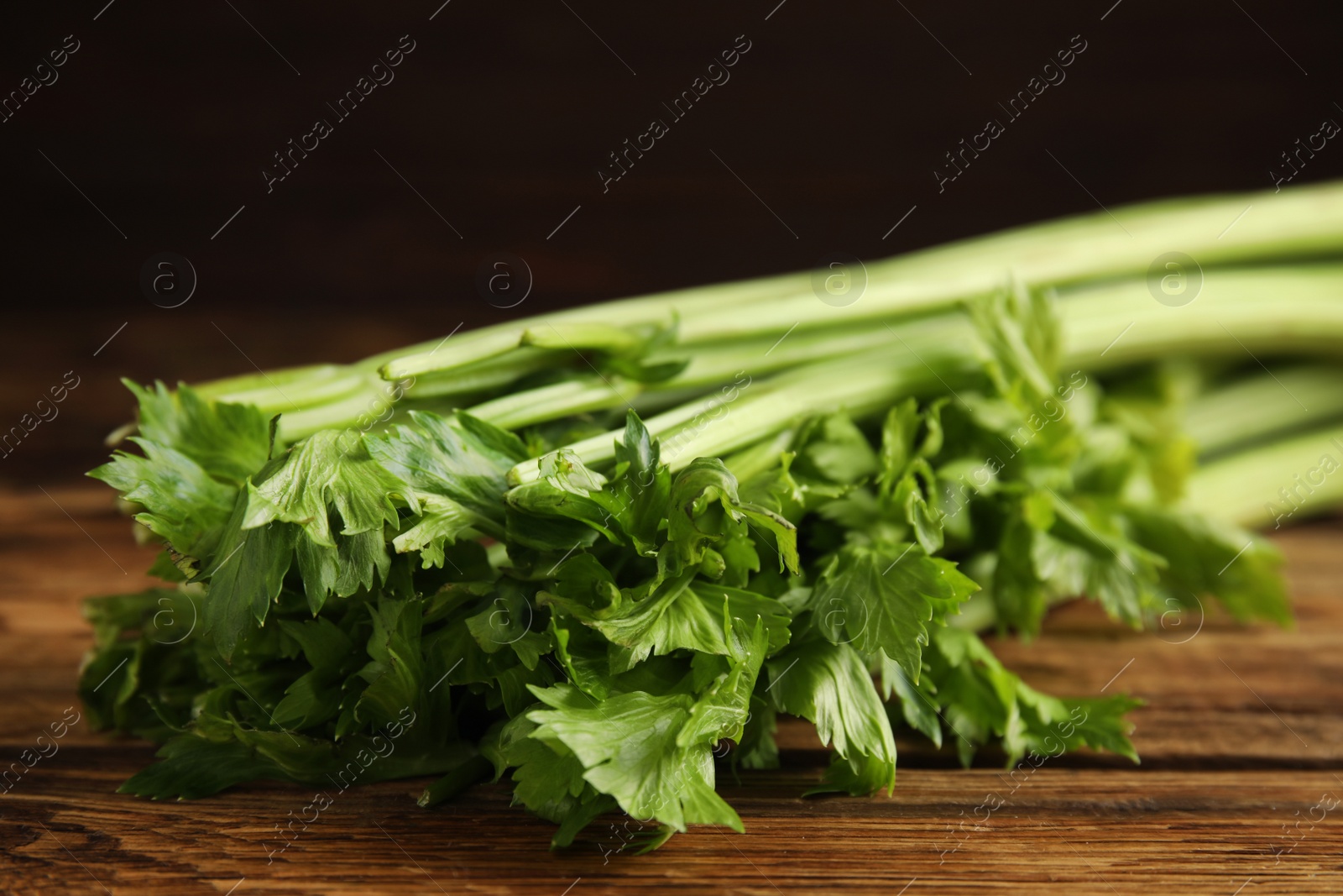 Photo of Fresh ripe green celery on wooden table, closeup