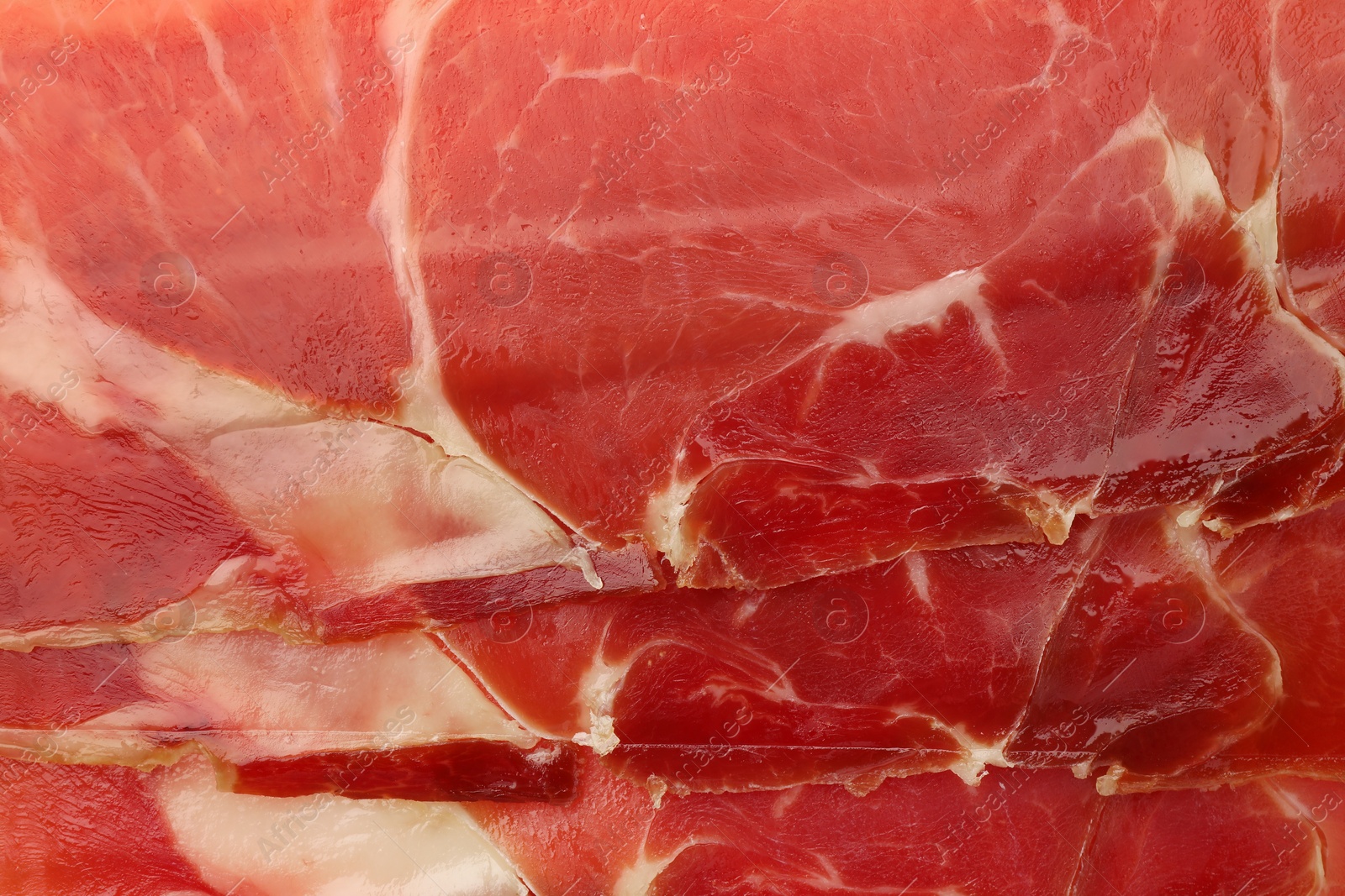 Photo of Delicious sliced jamon as background, top view