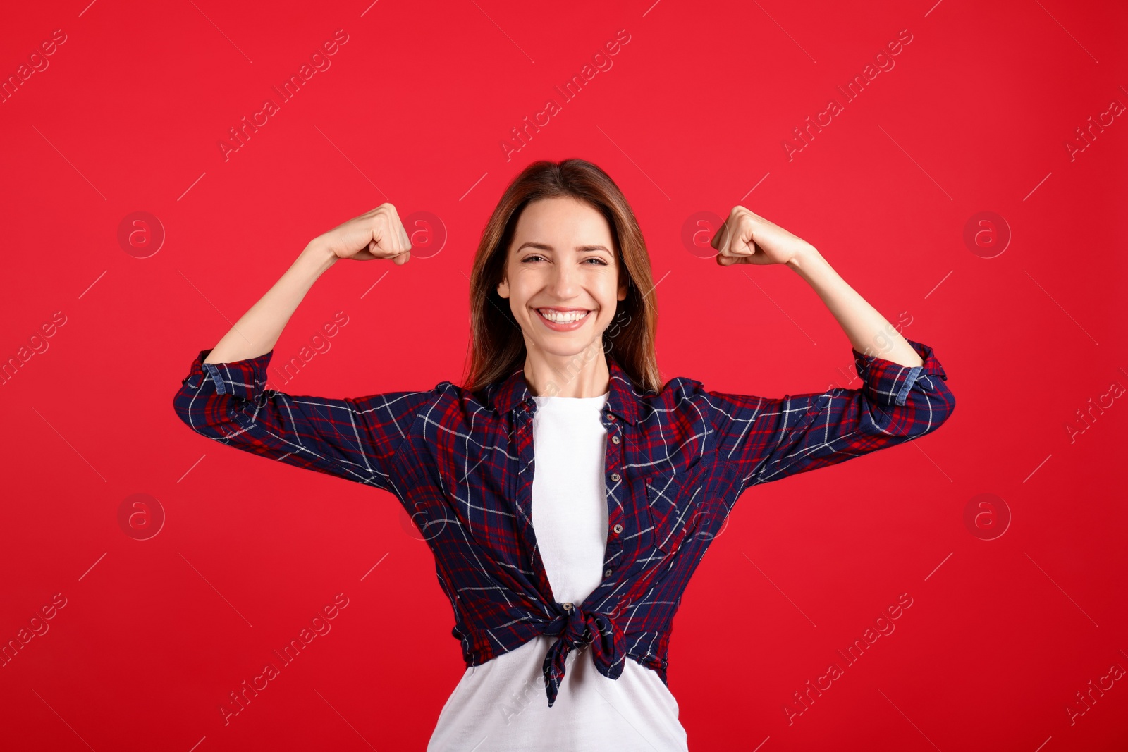 Photo of Strong woman as symbol of girl power on red background. 8 March concept